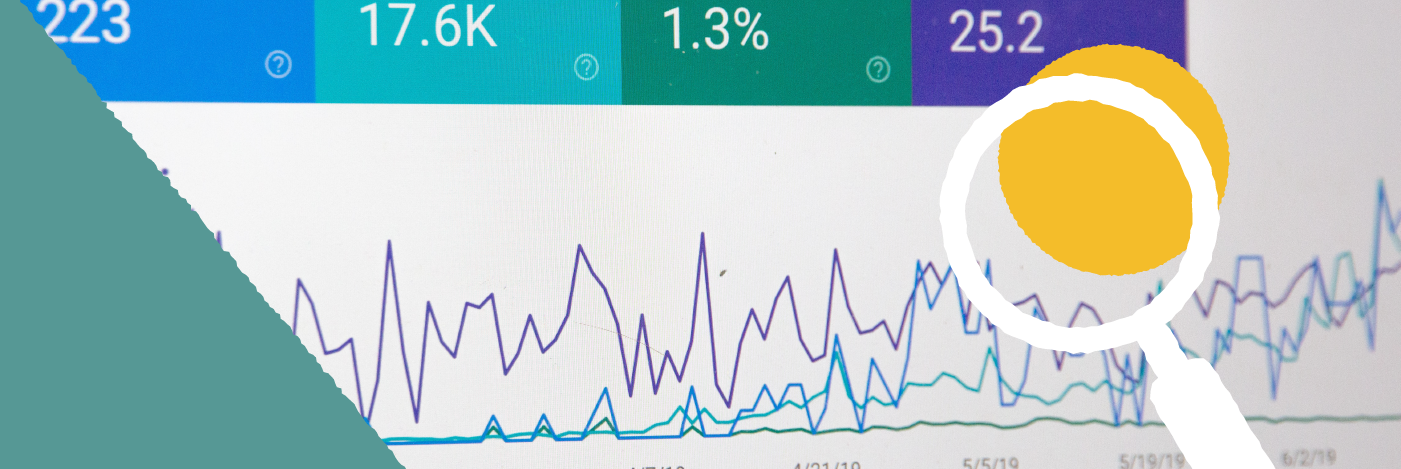 Photograph of analytics with magnifying glass symbol in front of it