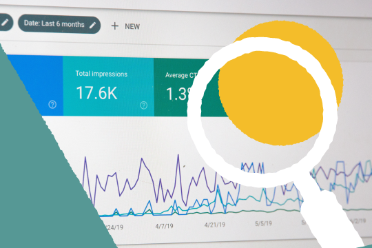 Photograph of analytics with magnifying glass symbol in front of it